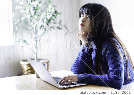 Young woman using a laptop in the room Young woman using a laptop in the room 115942661
