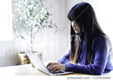 在房間裡使用筆記本電腦的年輕女子 115942666