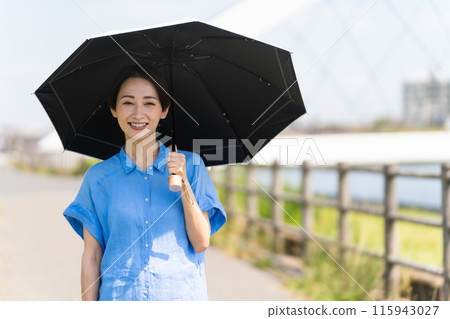 A young woman walking with a parasol Lifestyle image 115943027