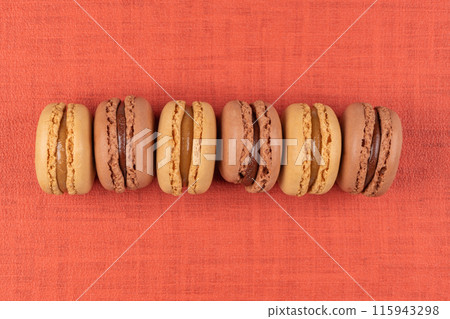 Six coffee and chocolated flavoured macaroons on vinyl background 115943298