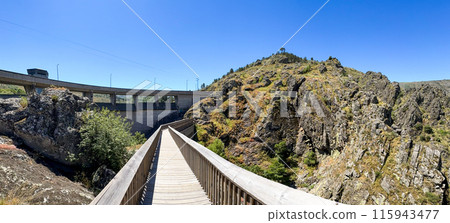Wooden Walkway Leading to a Dam 115943477