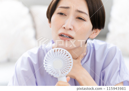 Young woman using a hand fan Lifestyle image Young woman using a hand fan Lifestyle image 115943981