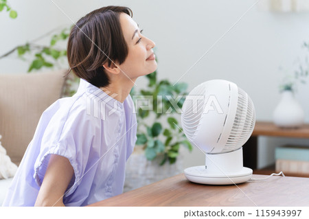 Young woman cooling off with an air circulator Lifestyle image 115943997