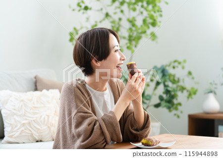 Young woman eating roasted sweet potato lifestyle image 115944898