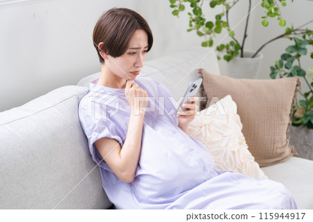 Pregnant woman operating a smartphone Lifestyle image 115944917