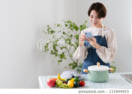 A young woman cooking in an apron Lifestyle image A young woman cooking in an apron Lifestyle image 115944953