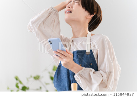 A young woman cooking in an apron Lifestyle image A young woman cooking in an apron Lifestyle image 115944957