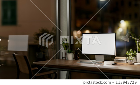 Contemporary private office at night features a computer with a white-screen mockup and a dim light. Contemporary private office at night features a computer with a white-screen mockup and a dim light. 115945729