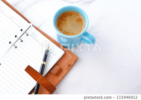 An image of someone writing in a diary while drinking a cafe latte, a coffee with plenty of milk. An image of someone writing in a diary while drinking a cafe latte, a coffee with plenty of milk. 115946912