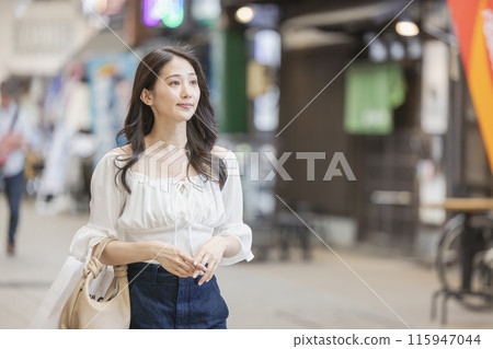 Young woman walking through a shopping street Young woman walking through a shopping street 115947044