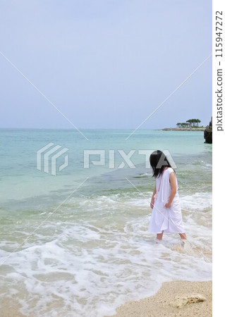 A girl wearing a dress standing on the beach A girl wearing a dress standing on the beach 115947272