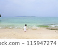 A girl wearing a dress standing on the beach 115947274