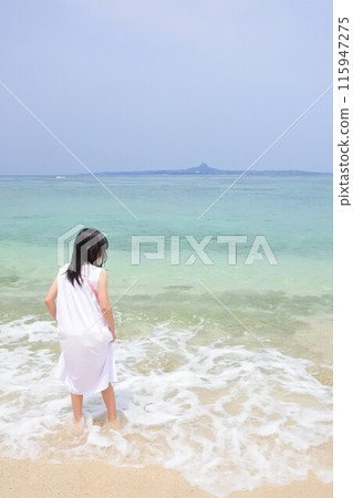 一個穿著裙子的女孩站在海灘上 一個穿著裙子的女孩站在海灘上 115947275