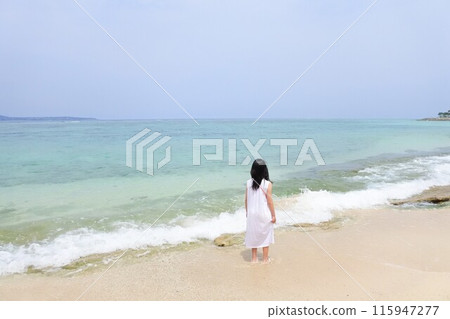 一個穿著裙子的女孩站在海灘上 一個穿著裙子的女孩站在海灘上 115947277