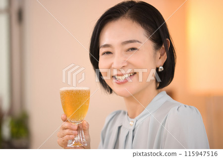 A middle-aged woman drinking beer with relish A middle-aged woman drinking beer with relish 115947516