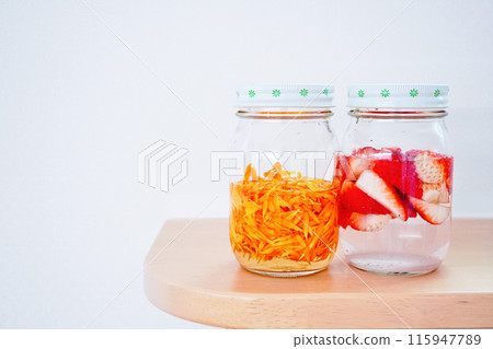 白色背景上排列成兩行的草莓金盞花花瓣天然酵母種子 白色背景上排列成兩行的草莓金盞花花瓣天然酵母種子 115947789