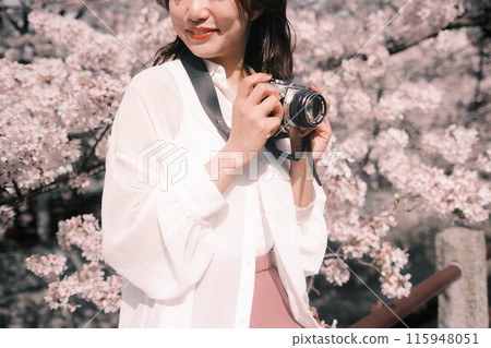 一個女人在欣賞櫻花時很開心 一個女人在欣賞櫻花時很開心 115948051