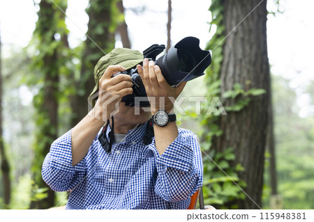 A man holding a camera 115948381