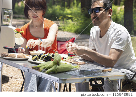 A couple in their 50s enjoying a BBQ 115948991