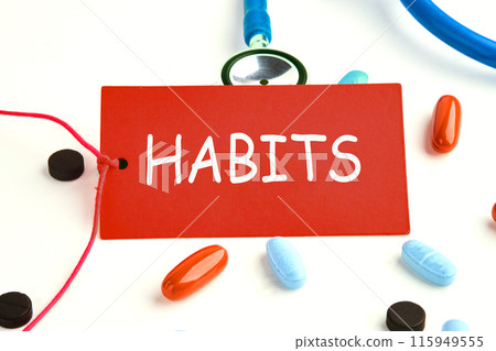Concept. Copy space. Text HABITS on a red card on a stethoscope with pills on the surface 115949555