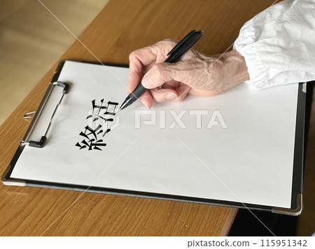 An elderly woman writing end-of-life messages on a white piece of paper held in a clipboard An elderly woman writing end-of-life messages on a white piece of paper held in a clipboard 115951342