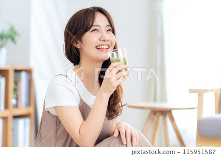 A young woman drinking vegetable juice A young woman drinking vegetable juice 115951587
