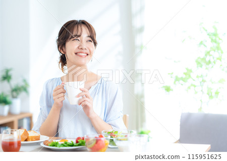 A young woman eating breakfast A young woman eating breakfast 115951625
