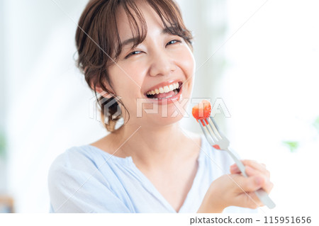 A young woman eating breakfast A young woman eating breakfast 115951656