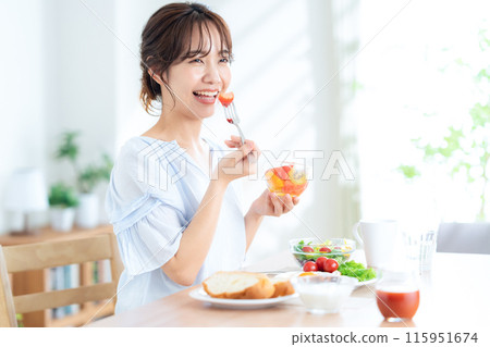A young woman eating breakfast A young woman eating breakfast 115951674