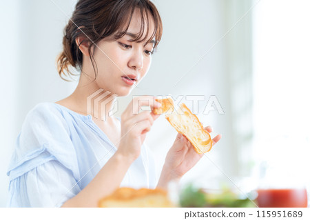 A young woman eating breakfast A young woman eating breakfast 115951689