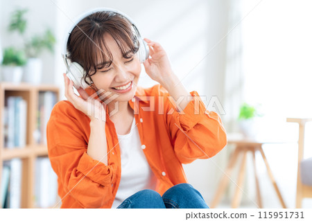 A woman listening to music with headphones A woman listening to music with headphones 115951731