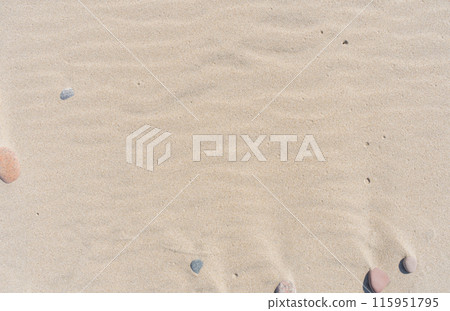 Sand and small stones on the beach. Sand texture. Brown sand. Abstract background 115951795