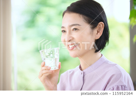 微笑的中年婦女在客廳喝水 115952164