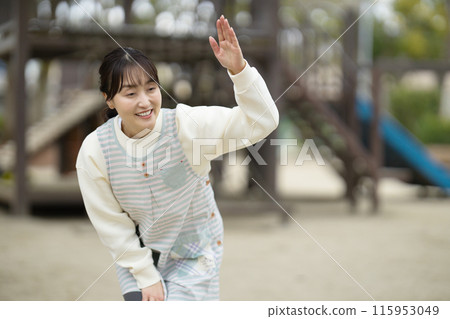 Nursery teacher watching over children in the park 115953049