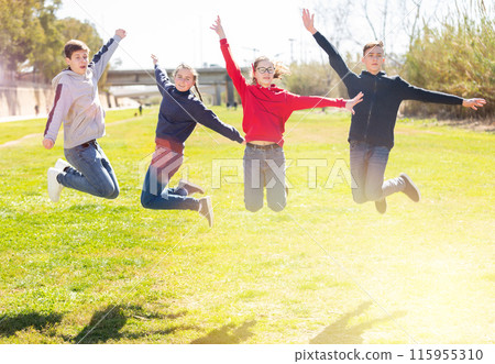 Cheerful teenages jumping in spring city park 115955310