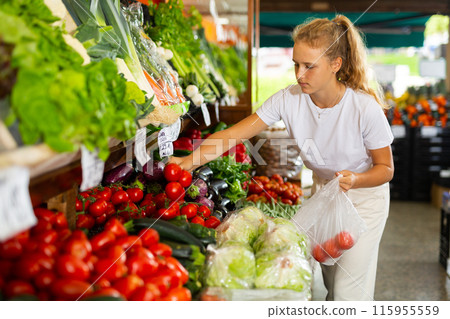 Fifteen-year-old girl shopper chooses fresh tomatoes Fifteen-year-old girl shopper chooses fresh tomatoes 115955559