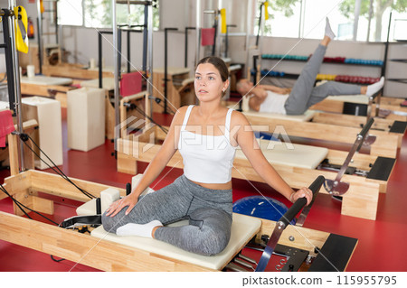 Young woman doing stretching on pilates reformer 115955795