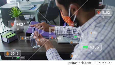 Image of social media icons over biracial man wearing face mask using hand sanitizer at office 115955938