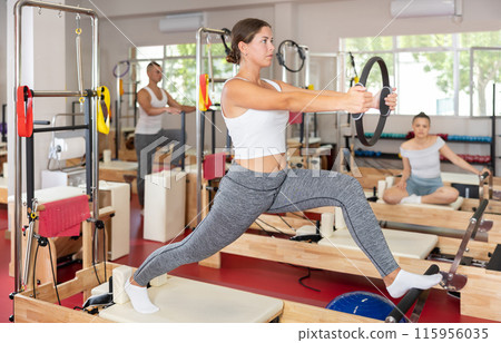 Young woman exercising with pilates ring Young woman exercising with pilates ring 115956035
