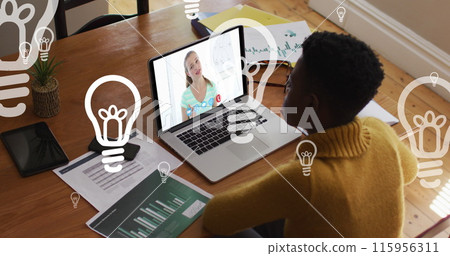 Image of bulbs floating over african american woman having image call on laptop Image of bulbs floating over african american woman having image call on laptop 115956311