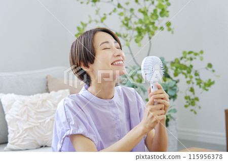 一位女士在客廳使用便攜式風扇 115956378