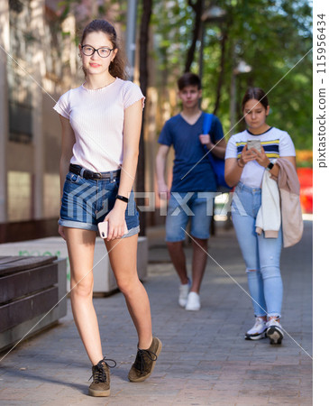 Cute teen girl walking down the street 115956434