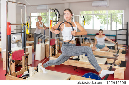 Young woman exercising with pilates ring 115956506