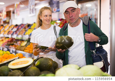 Man with a fifteen-year-old girl choose melons Man with a fifteen-year-old girl choose melons 115956954