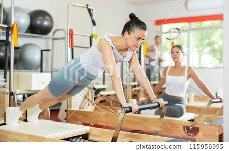 Young woman training her abs on pilates reformer 115956995