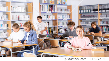Portrait of preteen girl reading books in college library Portrait of preteen girl reading books in college library 115957199