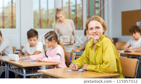 Portrait of schoolgirl at lesson in school 115957312