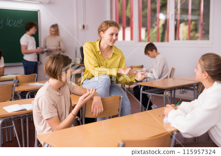 Teenage school pupils talking during break in classroom 115957324