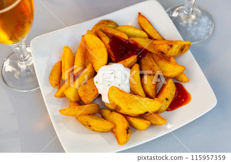 Homemade traditional Spanish fried potatoes Patatas bravas served tomato and sour cream with herb sauces Homemade traditional Spanish fried potatoes Patatas bravas served tomato and sour cream with herb sauces 115957359