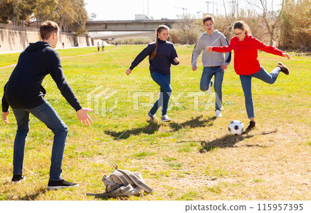 Cheerful teen friends playing with ball outdoors 115957395